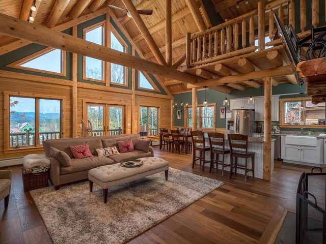 living room featuring plenty of natural light, lofted ceiling with beams, dark wood-style flooring, and wooden ceiling