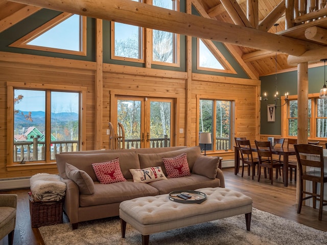 living area featuring a healthy amount of sunlight, wood walls, a notable chandelier, and french doors