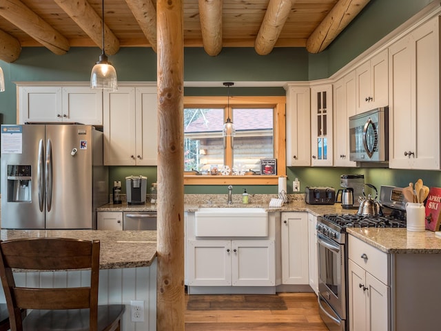 kitchen with wooden ceiling, wood finished floors, stainless steel appliances, pendant lighting, and beam ceiling