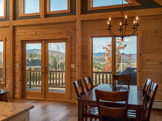 dining area with a notable chandelier, a mountain view, and wooden walls