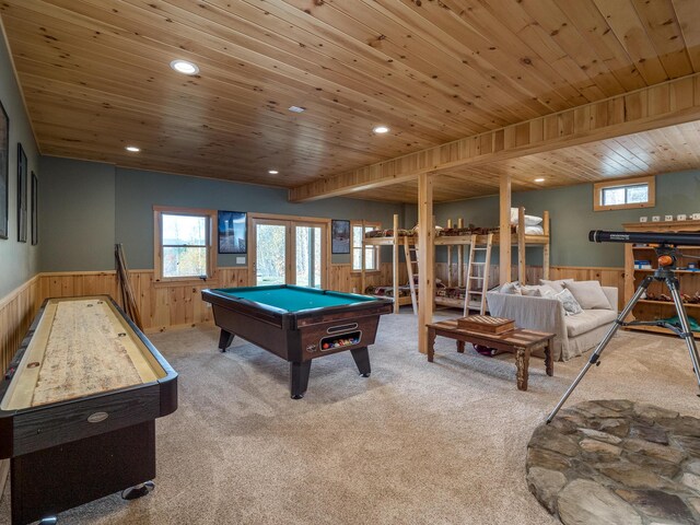 rec room with a wainscoted wall, wooden ceiling, and carpet