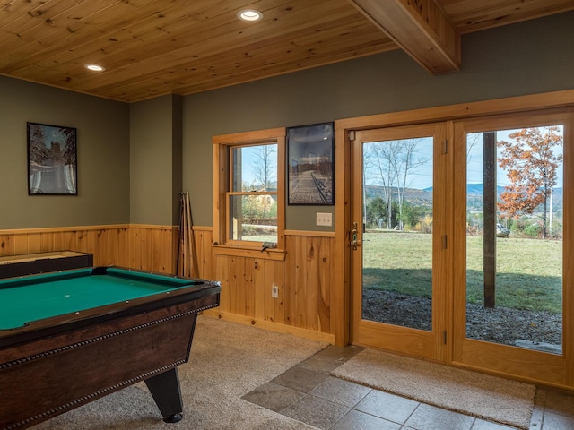 game room with a wainscoted wall, wooden ceiling, and plenty of natural light