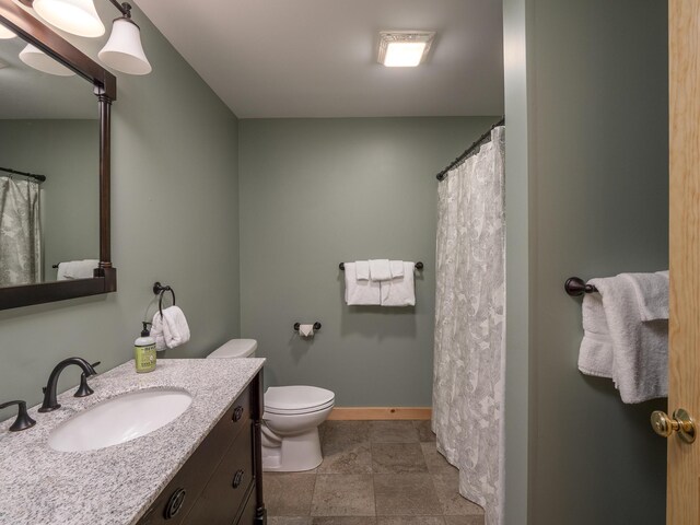 full bathroom featuring vanity, toilet, and baseboards