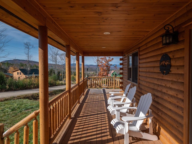 deck with covered porch and a mountain view