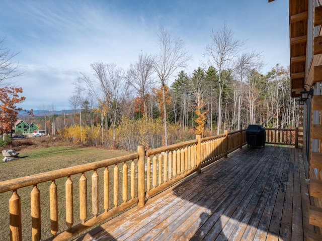 wooden terrace featuring grilling area and a yard