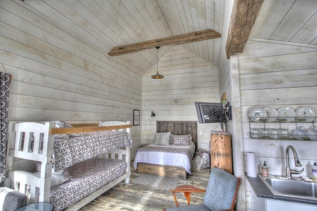 bedroom with wooden walls, wood ceiling, wood finished floors, vaulted ceiling with beams, and a sink