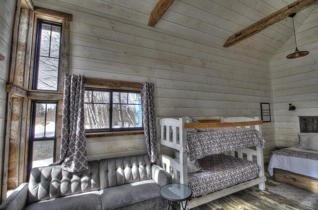 bedroom featuring lofted ceiling with beams, wood walls, wood ceiling, and wood finished floors