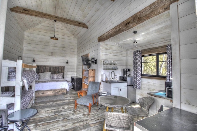 bedroom with vaulted ceiling with beams, a sink, wooden walls, wood finished floors, and wooden ceiling