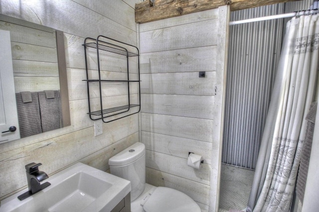 full bath featuring curtained shower, a sink, toilet, and wooden walls