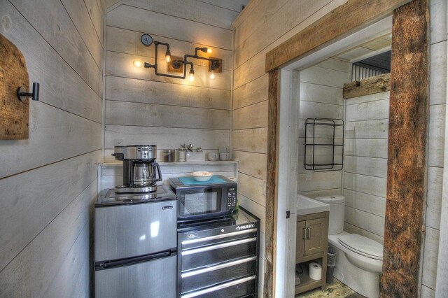 bathroom featuring wood walls and toilet