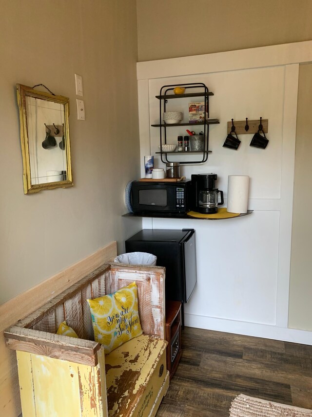 bar featuring black microwave and wood finished floors