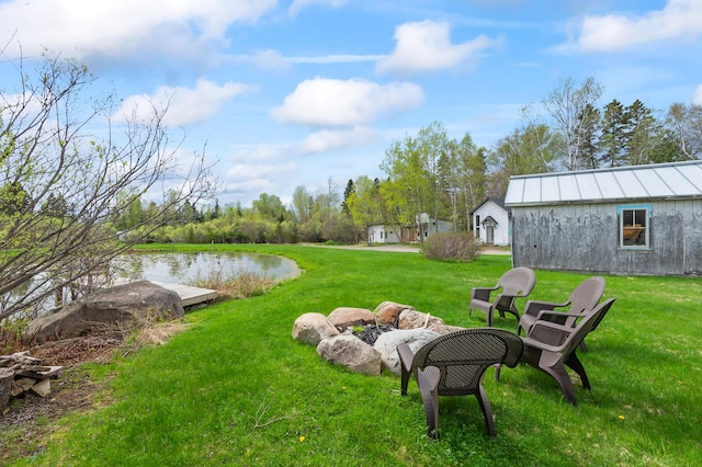 2342 Main St, Rangeley, ME 04970 - view of green lawn with an outdoor fire pit and a water view