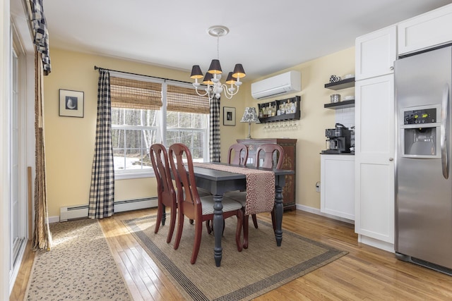 dining area featuring a baseboard radiator, a wall unit AC, light wood-type flooring, and a chandelier