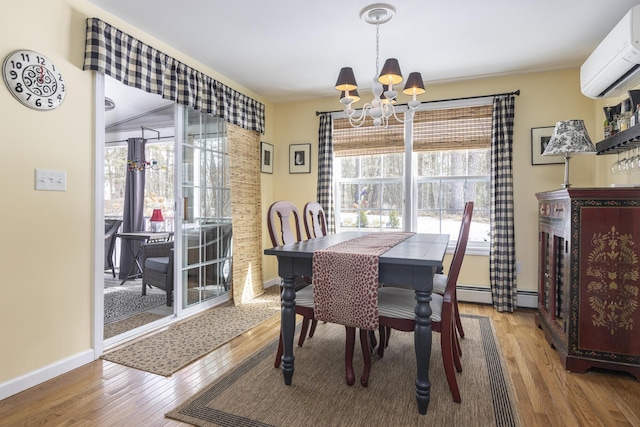 dining room featuring wood finished floors, baseboards, an AC wall unit, a baseboard heating unit, and a notable chandelier