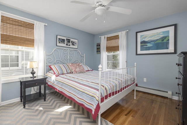 bedroom featuring wood finished floors, a ceiling fan, baseboards, and a baseboard radiator