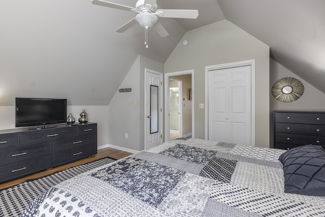 bedroom with lofted ceiling, wood finished floors, a closet, baseboards, and ceiling fan