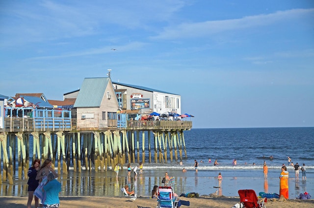 property view of water with a pier and a view of the beach