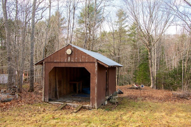 view of outdoor structure with a wooded view and an outdoor structure