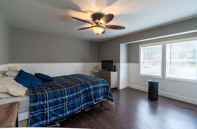 bedroom with wainscoting, ceiling fan, and wood finished floors