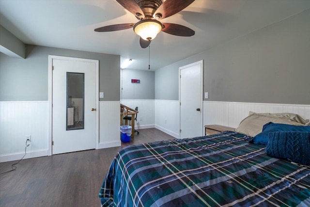 bedroom featuring wood finished floors, a wainscoted wall, and ceiling fan