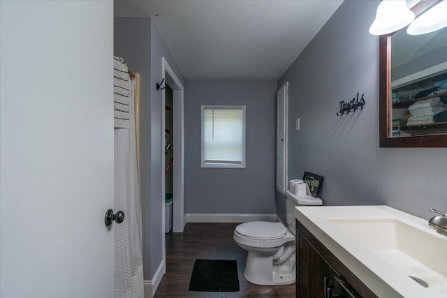 full bath with toilet, vanity, baseboards, and wood finished floors