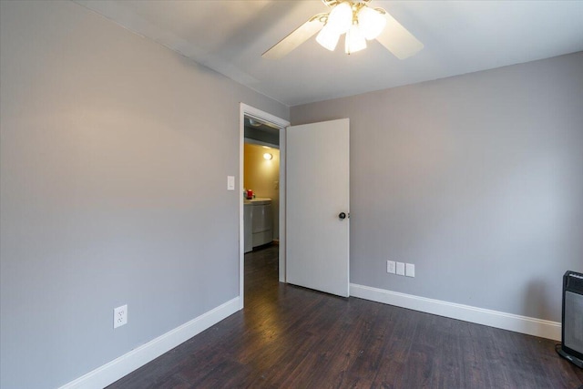 unfurnished room featuring washer / clothes dryer, baseboards, dark wood finished floors, and a ceiling fan