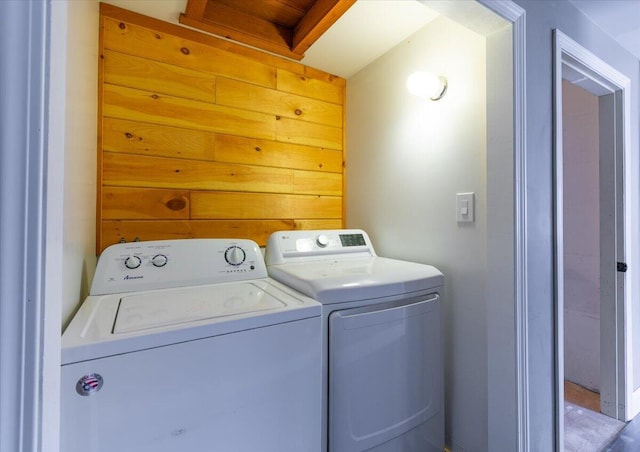 laundry room featuring laundry area, independent washer and dryer, and wood walls