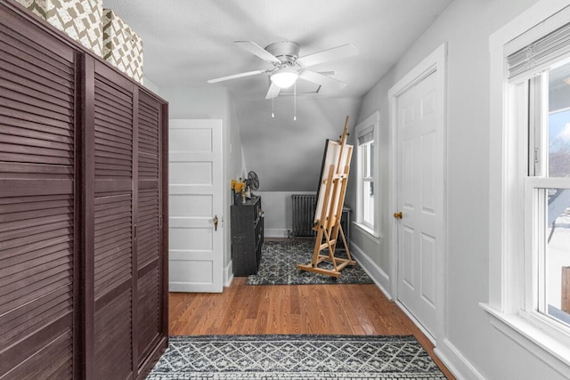 interior space featuring a wealth of natural light, baseboards, wood finished floors, and radiator heating unit