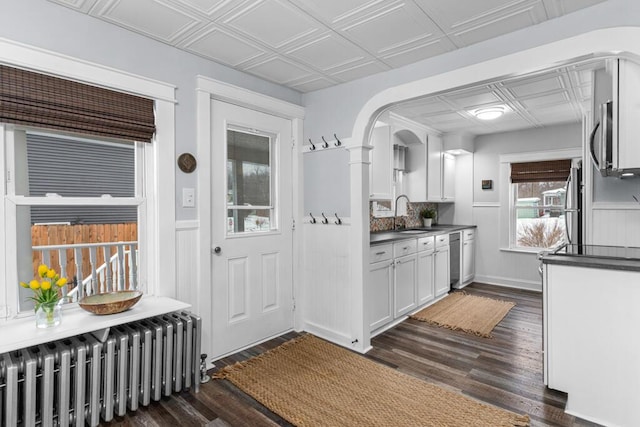 kitchen featuring dark countertops, an ornate ceiling, radiator heating unit, and a sink