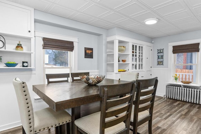 dining area with dark wood finished floors, an ornate ceiling, and radiator heating unit