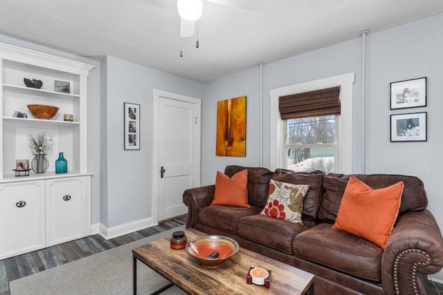 living area with ceiling fan, baseboards, and dark wood-style floors