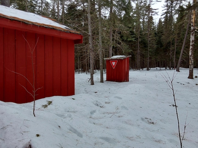 yard covered in snow with an outbuilding