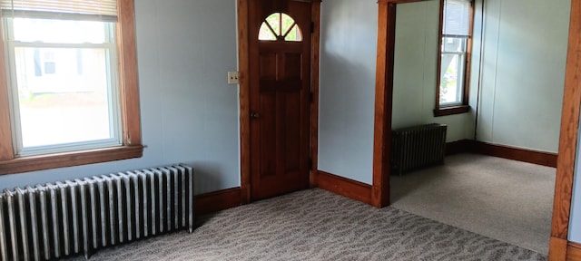 carpeted foyer entrance featuring radiator and baseboards