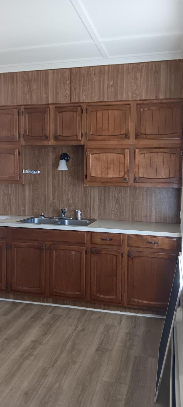 kitchen featuring brown cabinetry, light countertops, and wood finished floors