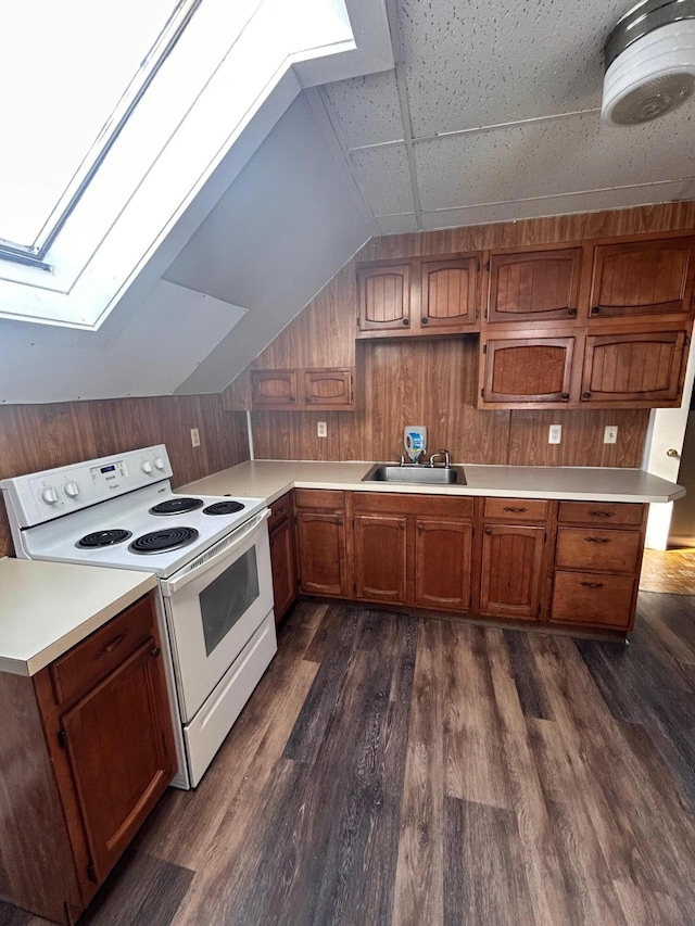 kitchen featuring light countertops, wooden walls, dark wood-style flooring, and white range with electric cooktop