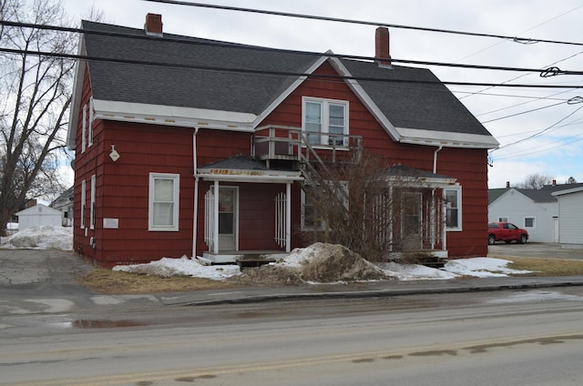 view of front of home with a chimney and a shingled roof