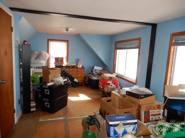 bonus room featuring lofted ceiling, plenty of natural light, and concrete floors