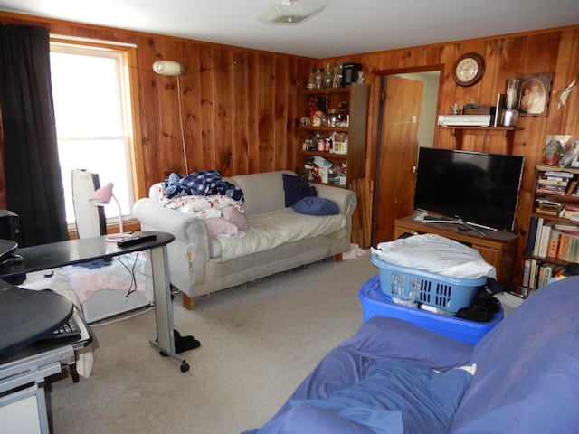 carpeted living area with wooden walls