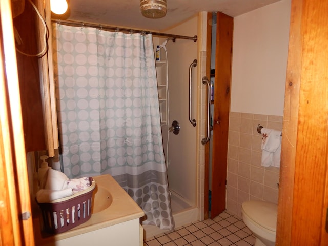 full bathroom with toilet, tile walls, a shower stall, tile patterned flooring, and vanity