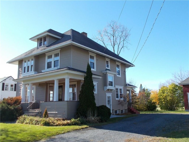 view of front of home featuring covered porch and a chimney