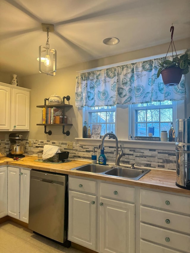 kitchen with white cabinetry, dishwasher, a sink, and wooden counters