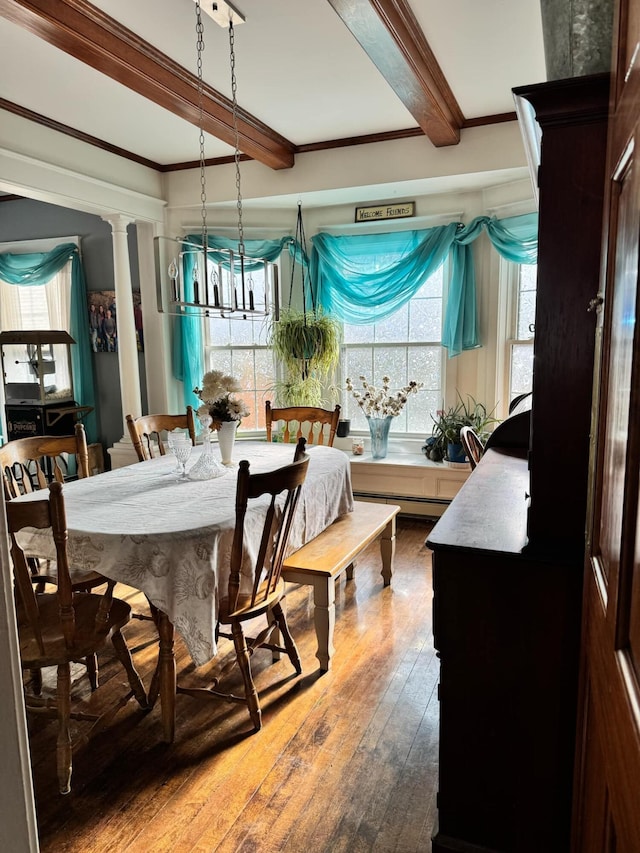 dining room with crown molding, wood-type flooring, beamed ceiling, and decorative columns