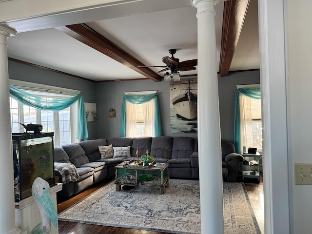 living area featuring beamed ceiling, wood finished floors, decorative columns, and a healthy amount of sunlight