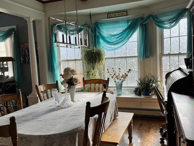 dining space with ornate columns, a baseboard radiator, and dark wood-style floors