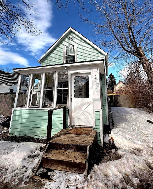 exterior space with fence and a sunroom