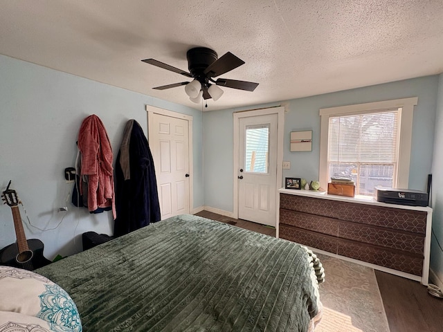 bedroom featuring ceiling fan, baseboards, and a textured ceiling