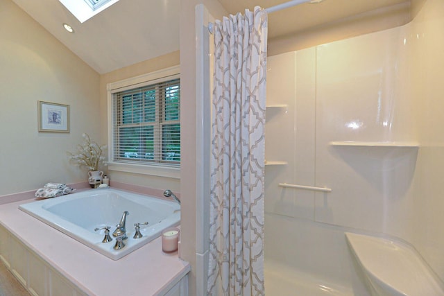 bathroom with a shower with shower curtain, vaulted ceiling with skylight, and a garden tub