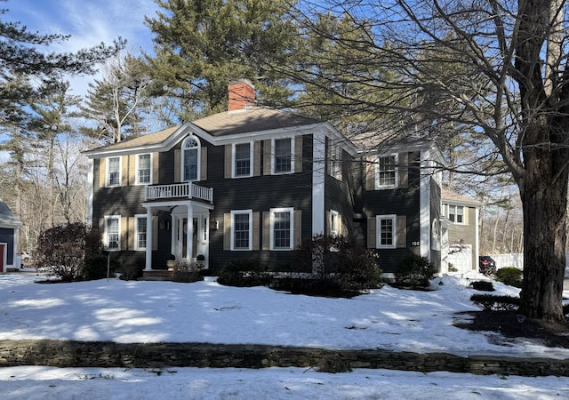 colonial-style house with a balcony and a chimney