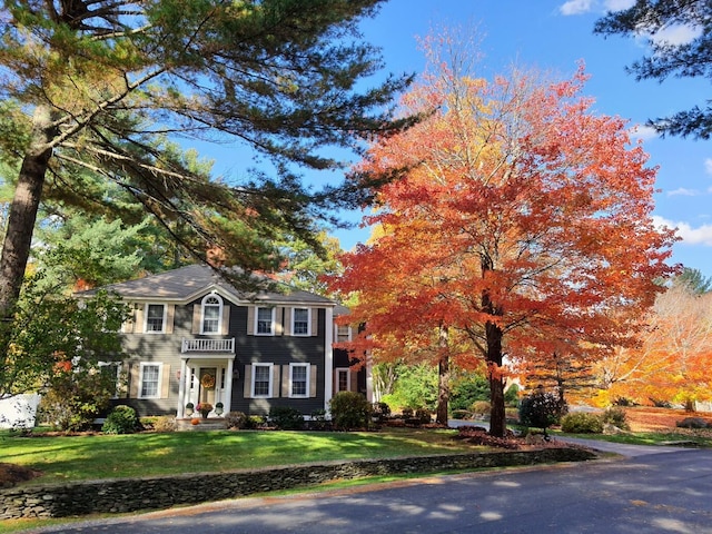 view of front of house featuring a front lawn and a balcony