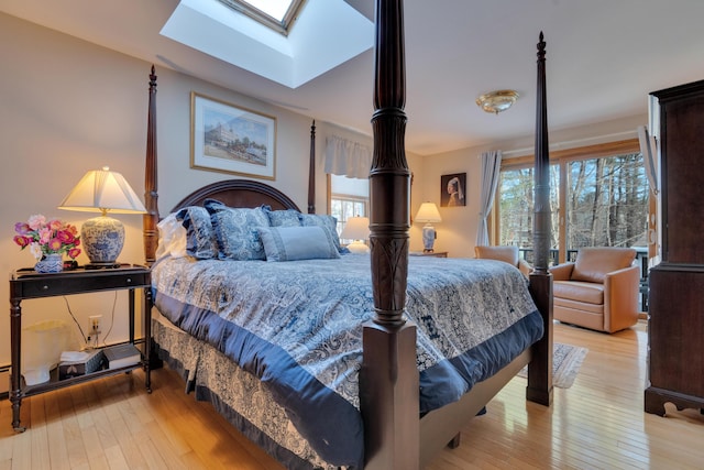 bedroom with hardwood / wood-style floors and a skylight